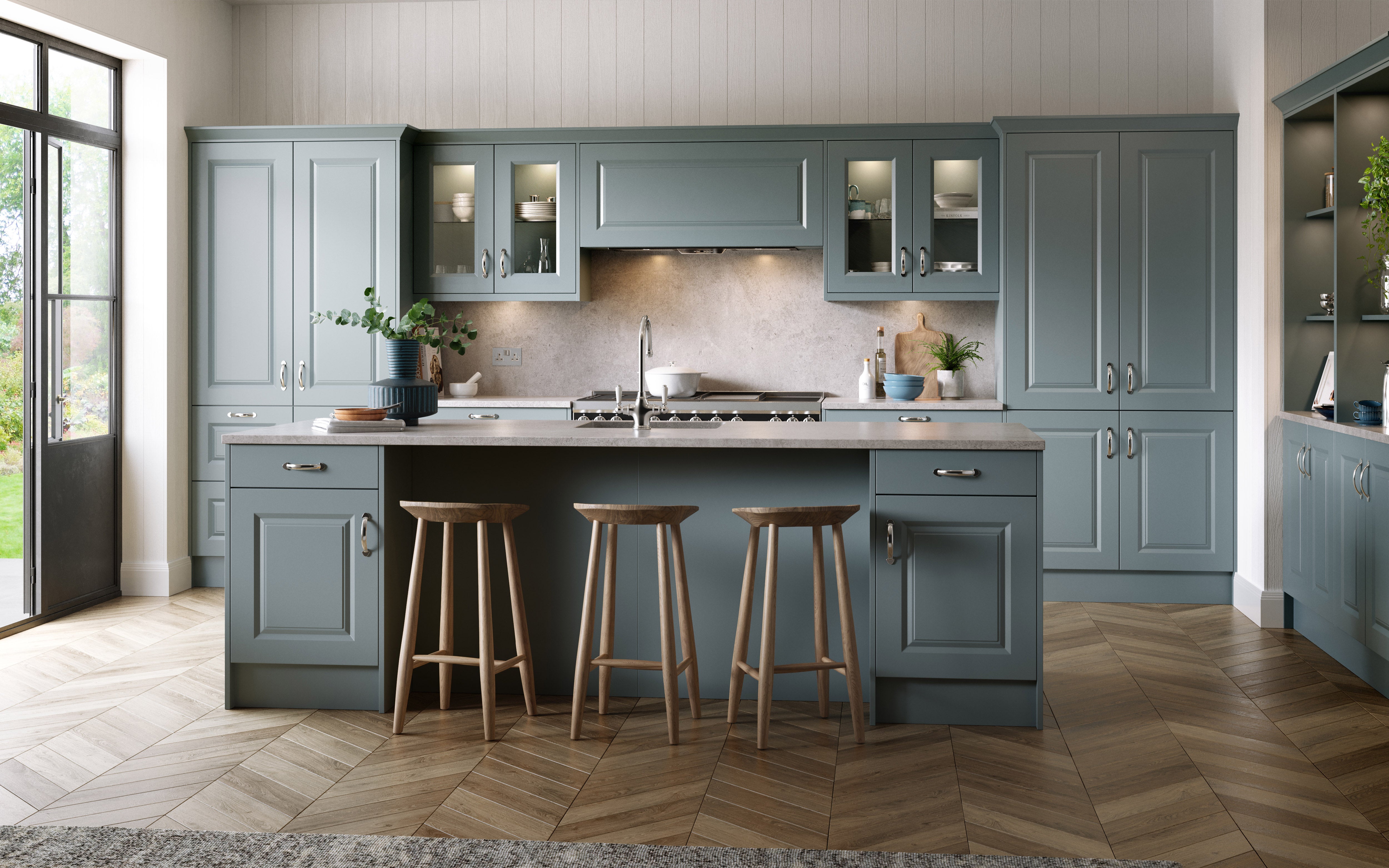 Modern kitchen with grey cabinets, wooden floor, and bar stools.