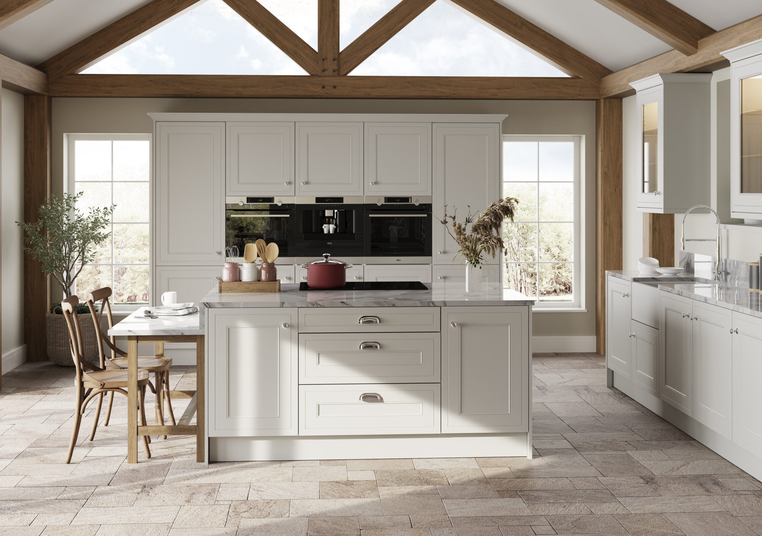 Modern kitchen with light grey cabinetry, island, and wooden flooring.