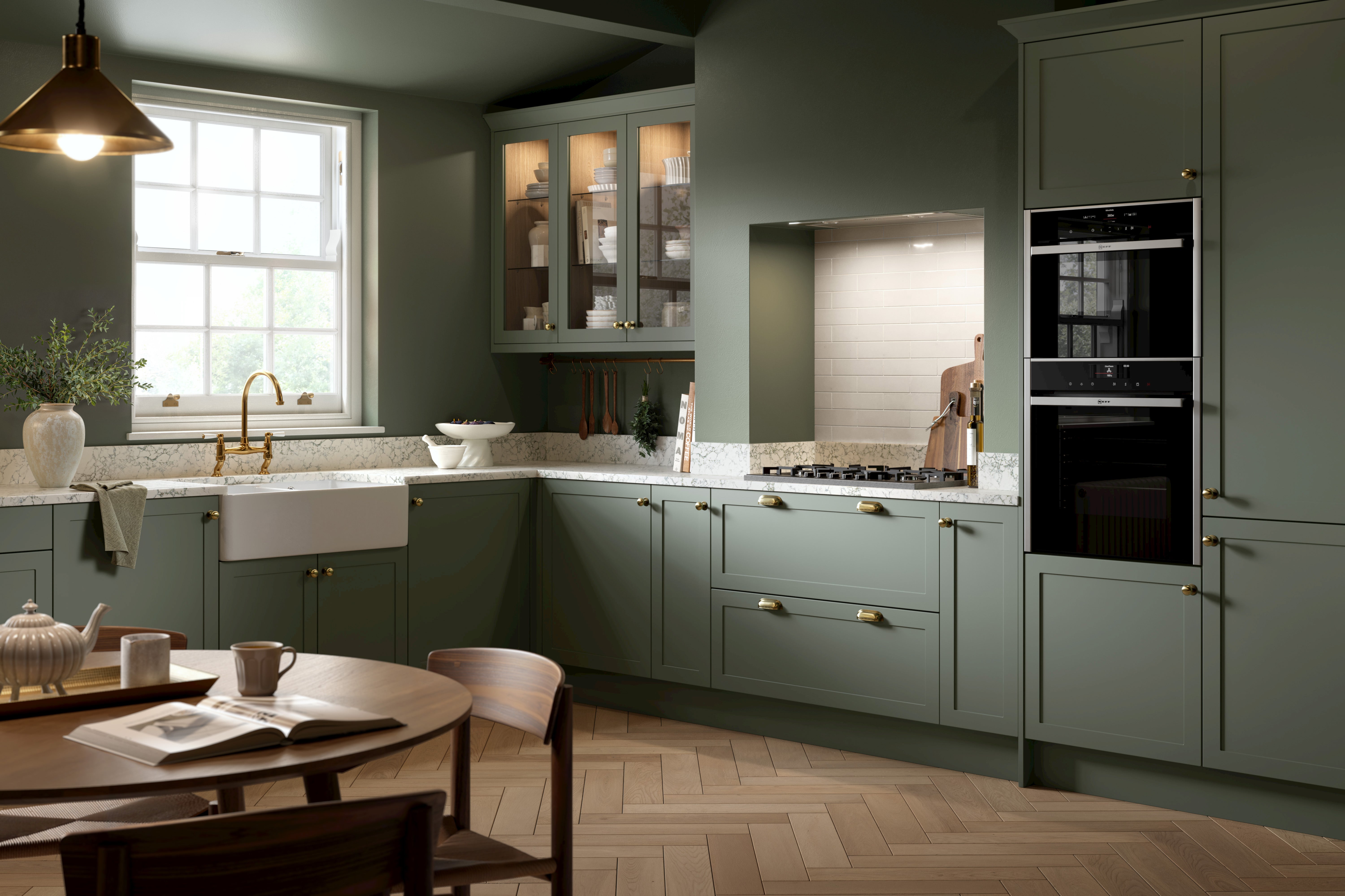 Modern kitchen with green cabinets, a sink, and a dining table.