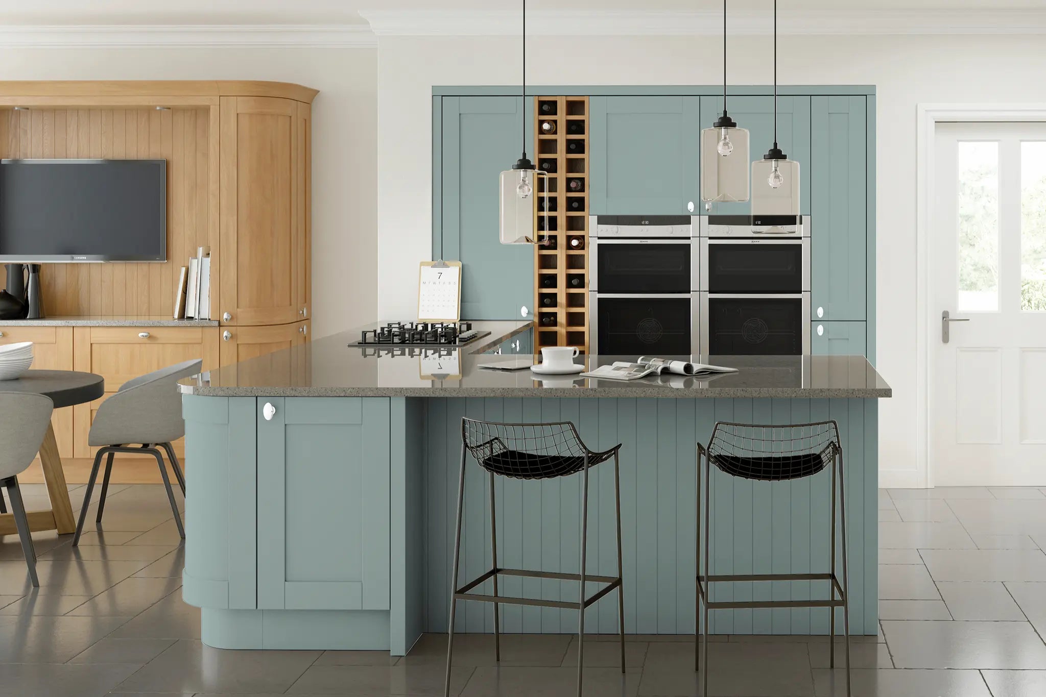 Modern shaker kitchen with grey island, black bar stools, and wooden cabinets.