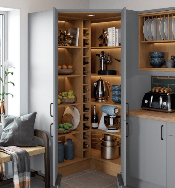 Open kitchen pantry with wooden shelves filled with kitchenware and appliances.