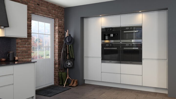Modern Jayline kitchen with light grey cabinets, black appliances, and a brick wall.
