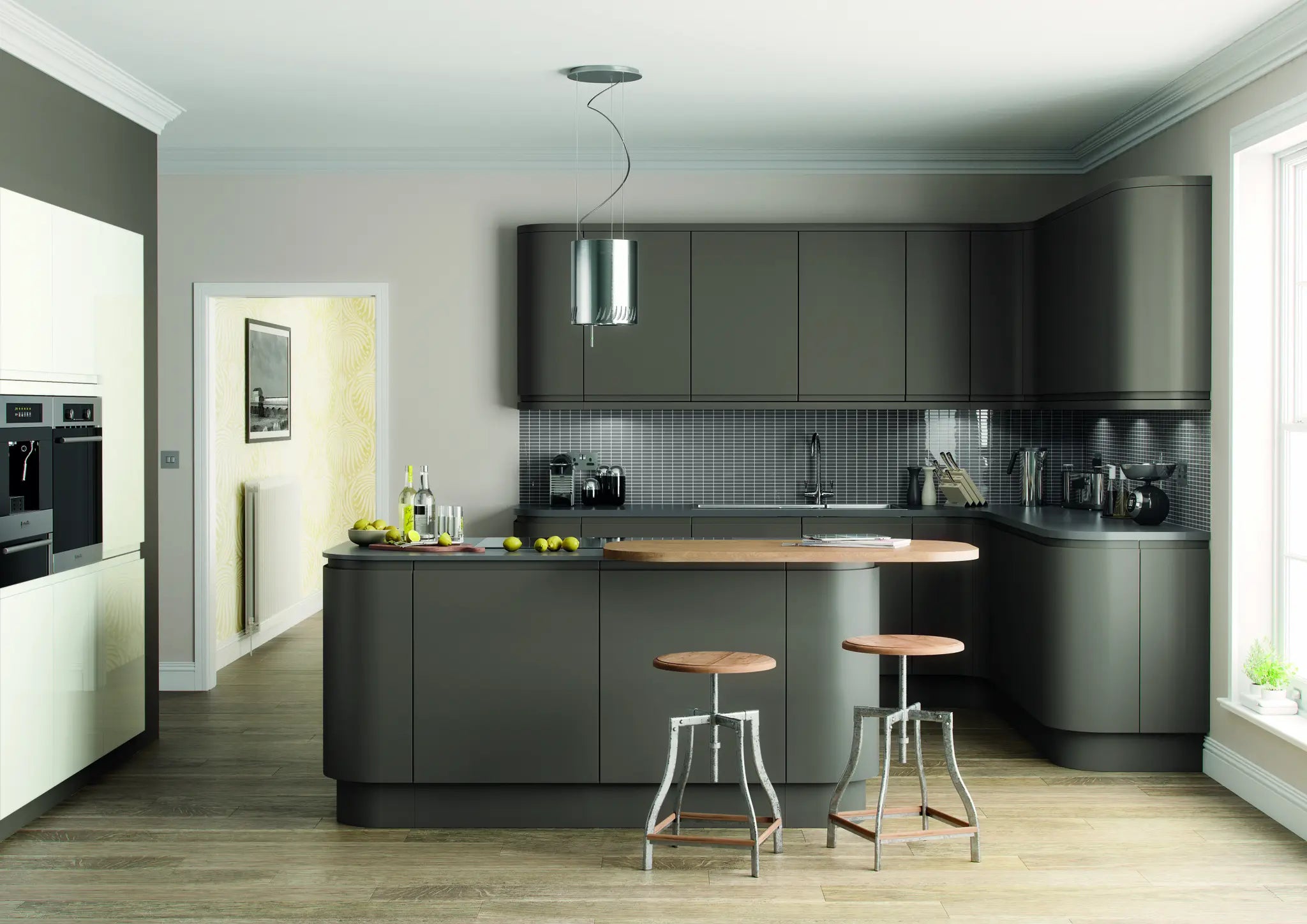 Modern kitchen with dark grey cabinets, wooden island, and stools.