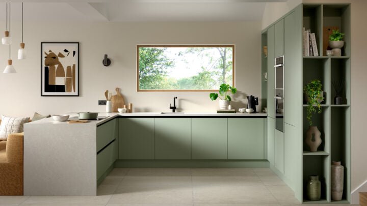 Modern kitchen with green cabinets, white countertops, and a window view.