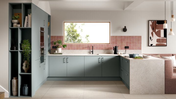 Modern kitchen with grey cabinets, white countertops, and a pink backsplash.