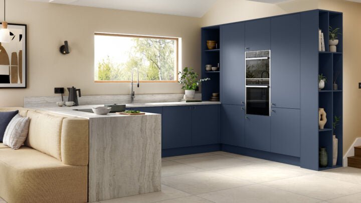 Ora kitchen with blue cabinets, white countertop, and beige sofa.