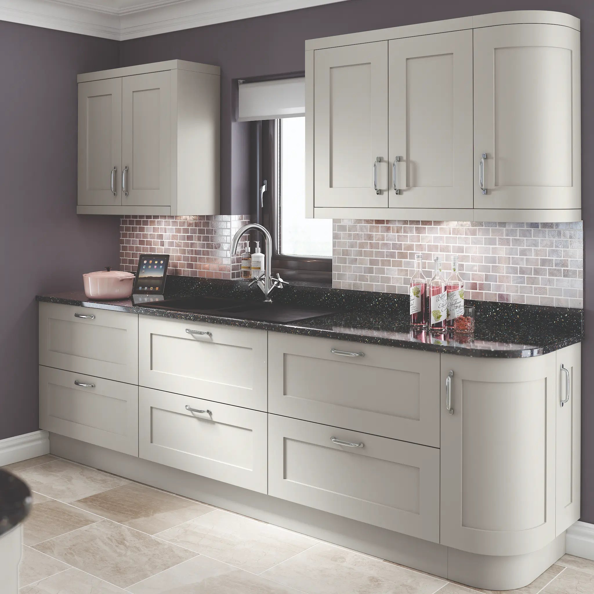 Oxford shaker kitchen with light grey cabinets, doors and plinth. With black countertop, and tiled backsplash.