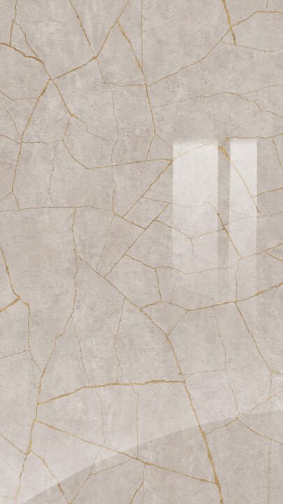Beige ceramic tile with gold accents on a textured background