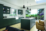 Bella Carrick Matt Kombuu Green kitchen,featuring glazed doors and an island. White marble worktops.