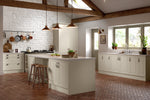 Modern kitchen with off-white cabinetry, island, and brick flooring.
