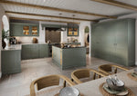 Modern shaker kitchen with green cabinets, island, and wooden chairs.