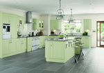 Modern shaker kitchen with sage green cabinet doors, stainless steel appliances, and grey worktops.
