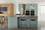 Modern kitchen with grey island, black bar stools, and wooden cabinets.