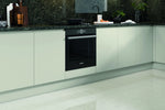Modern handless Lucente kitchen with a built-in oven and light green cabinet doors.