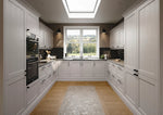 Rydal kitchen with cashmere doors, plinth and cornice. Black appliances, and a large window.