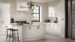 Modern Ora kitchen with white cabinets, island, and black bar stools.