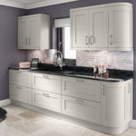 Modern kitchen with grey cabinets, black countertop, and tiled backsplash.