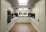 Modern shaker kitchen with sage green cabinet doors, black countertops and tiles.