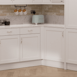 Kitchen corner with white cabinets, marble countertop, and a blue toaster.