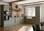 Modern kitchen with green cabinets, brick wall, and wooden floor.