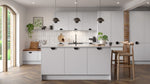 Zurfiz kitchen with light grey cabinets, wooden floor, and pendant lights.