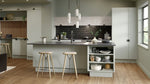 Modern kitchen with grey island, bar stools, and white cabinets.